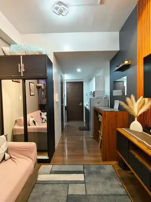 a room with a bed and a kitchen with a desk at Cozy Crib @ Air Residences - Makati in Manila