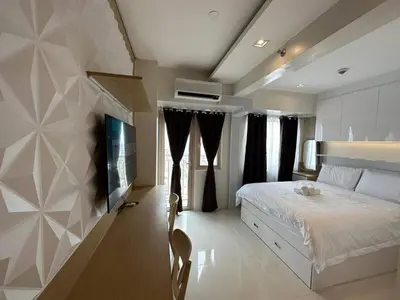 a bedroom with a bed and a tv on a wall at Coast Residences Penthouse with skyline and manila bay view in Manila