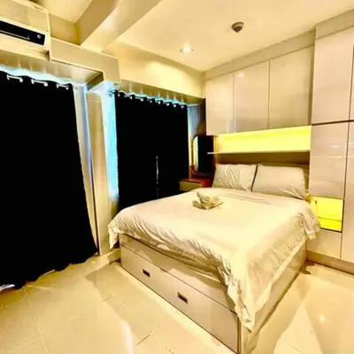 a bedroom with a bed and a large window at Coast Residences Penthouse with skyline and manila bay view in Manila
