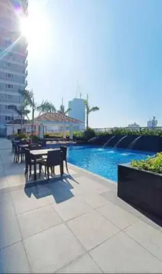 a patio with a table and chairs next to a pool at Coast Residences Penthouse with skyline and manila bay view in Manila
