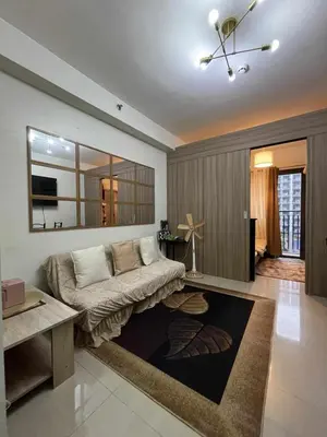 a living room with a couch and a mirror at Shore 3 Residences MOA Manila in Manila