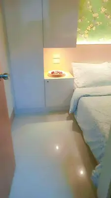 a small bedroom with a bed and a night stand at Shore 3 Residences MOA Manila in Manila