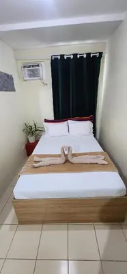 a bedroom with two beds and a curtain at URBAN DECA O1257 Ortigas near SM EAST PASIG in Manila