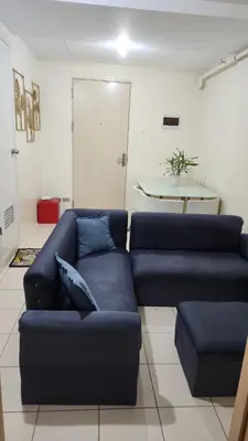 a living room with a blue couch and a table at URBAN DECA O1257 Ortigas near SM EAST PASIG in Manila