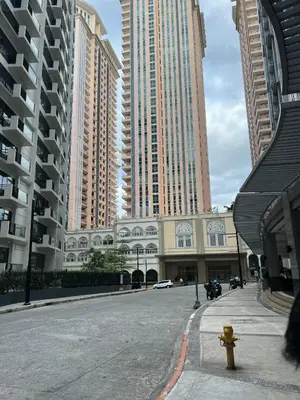a city street with tall buildings and a yellow fire hydrant at Condotel in Venice Grand Canal Mall Taguig in Manila