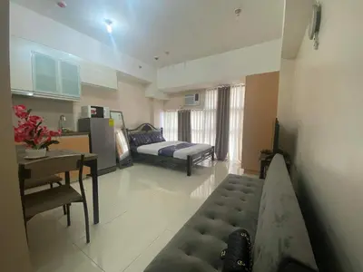 a living room with a couch and a bed and a table at Condotel in Venice Grand Canal Mall Taguig in Manila