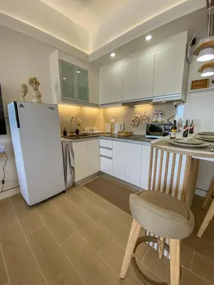 a kitchen with a refrigerator and a table and a chair at nJoy! BOHO Luxury at Venice Grand Canal in Manila