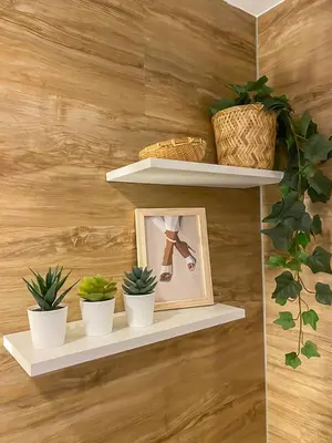 a wall with shelves with potted plants and a picture at nJoy! BOHO Luxury at Venice Grand Canal in Manila