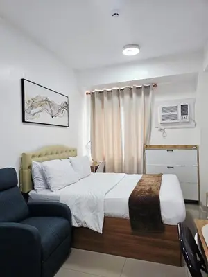 a bedroom with a large bed and a couch at Acellyne's Suites at Green 2 Residences with Netflix! in Dasmariñas