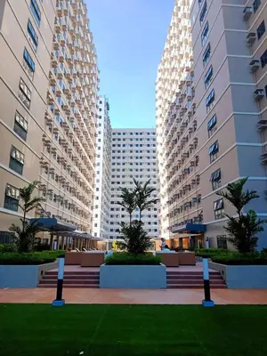 two tall buildings with palm trees in a park at Acellyne's Suites at Green 2 Residences with Netflix! in Dasmariñas
