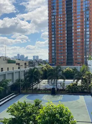 a tennis court in front of a tall building at Cubao Manhattan, U 8J T D,Studio in Manila