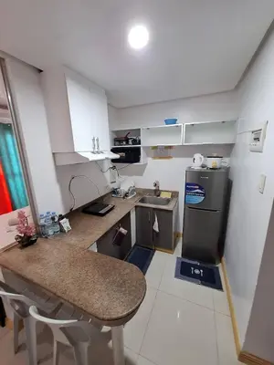 a small kitchen with a sink and a refrigerator at BirchTower Studio Condo with Balcony & Pool - Carosa Staycation in Manila
