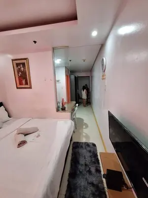 a room with a bed and a desk and a mirror at BirchTower Studio Condo with Balcony & Pool - Carosa Staycation in Manila