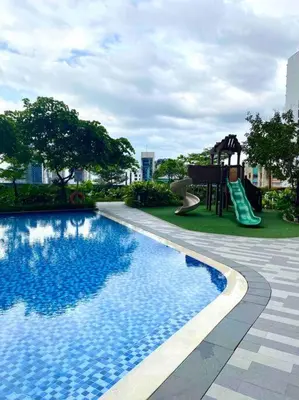 a swimming pool with a slide and a playground at Scandinavian Studio in Makati in Manila