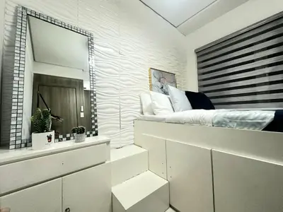 a white bedroom with a bed and a mirror at Coast Stay by J 40th floor Penthouse in Manila