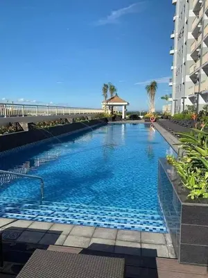 a large swimming pool in front of a building at Coast Stay by J 40th floor Penthouse in Manila