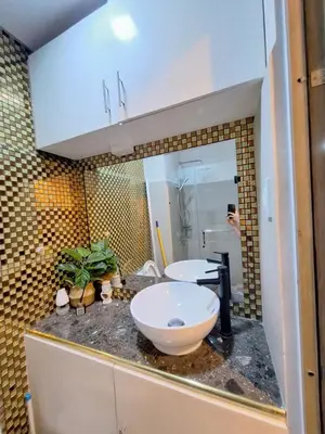 a person taking a picture of a bathroom with a sink at Coast Stay by J 40th floor Penthouse in Manila