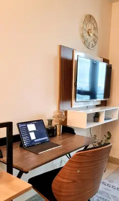 a desk with a laptop and a television on it at Luxe Bonifacio Global City Taguig Uptown Condo Hotel 1 BR Suite in Manila