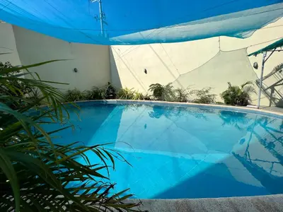 a large blue swimming pool with a blue umbrella at Staycation Condotel Room To Stay in Manila