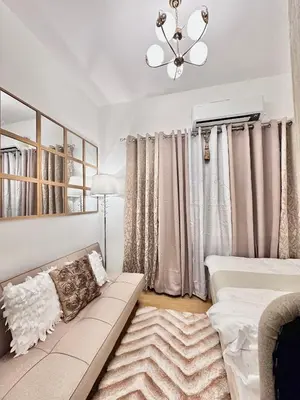 a living room with a couch and a chandelier at 9th Queen Size One Bedroom in Grace Residences, Taguig in Manila