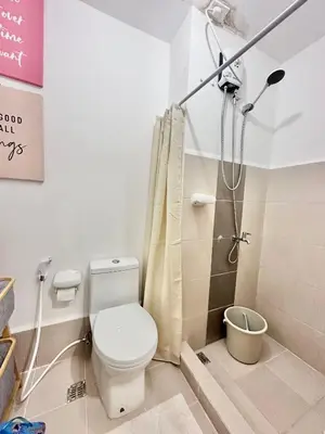 a bathroom with a toilet and a shower at 9th Queen Size One Bedroom in Grace Residences, Taguig in Manila