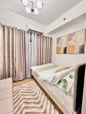a bedroom with two beds and a ceiling fan at 9th Queen Size One Bedroom in Grace Residences, Taguig in Manila