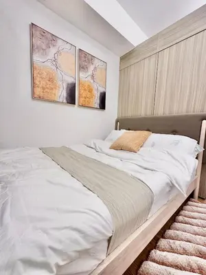 a bedroom with a bed with two pictures on the wall at 9th Queen Size One Bedroom in Grace Residences, Taguig in Manila