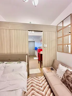 a bedroom with a bed and a couch and a table at 9th Queen Size One Bedroom in Grace Residences, Taguig in Manila